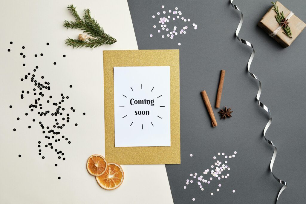 pexels-photo-5499120-5499120 A festive holiday-themed flat lay featuring a 'Coming Soon' greeting card with decorative elements.